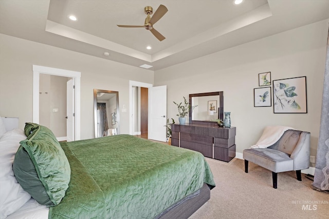 bedroom featuring light carpet, a tray ceiling, baseboards, recessed lighting, and a ceiling fan