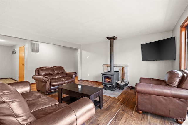 living room with hardwood / wood-style floors and a wood stove