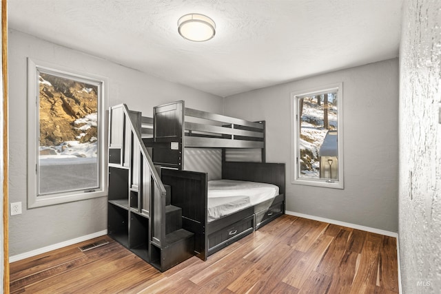 bedroom featuring hardwood / wood-style floors and a textured ceiling