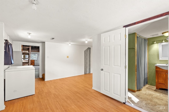 interior space with fridge and light hardwood / wood-style flooring