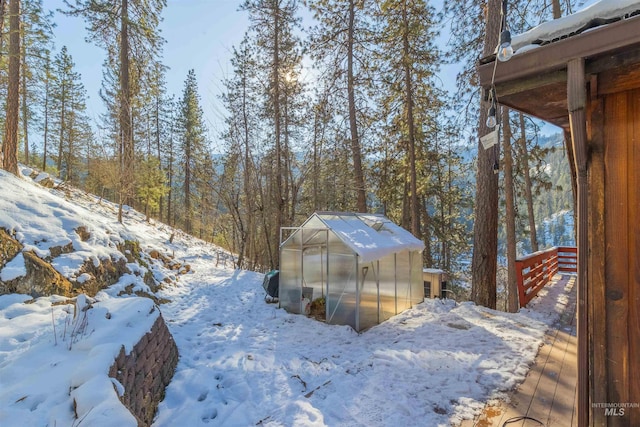 snowy yard featuring an outbuilding