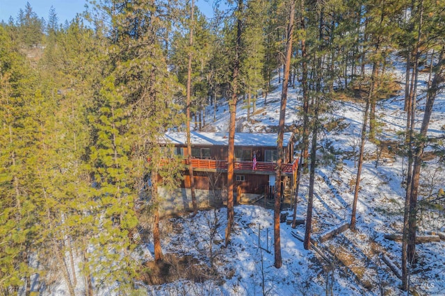 snow covered rear of property featuring a wooden deck