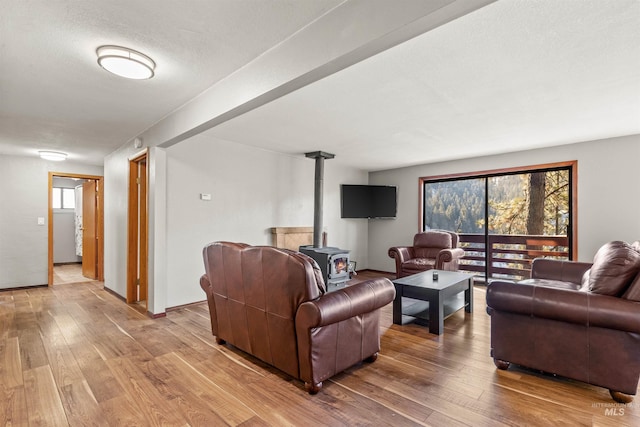 living room featuring a wood stove, hardwood / wood-style floors, and a textured ceiling