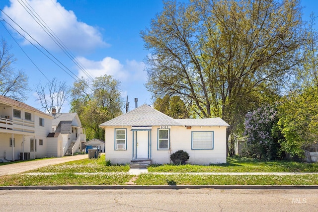 bungalow-style home featuring driveway and roof with shingles