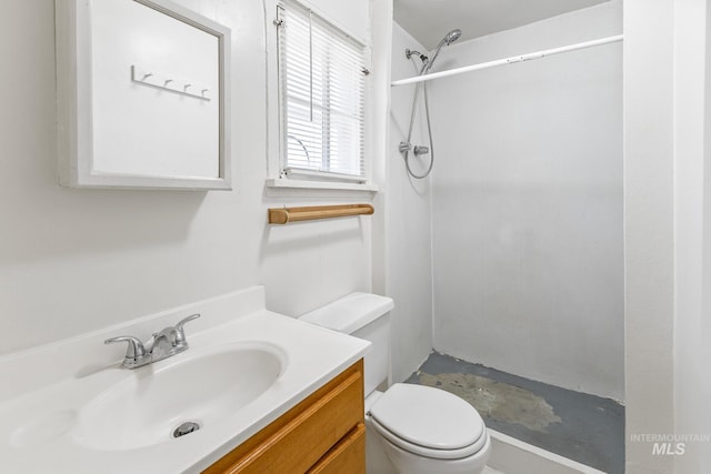 bathroom featuring toilet, a shower stall, and vanity