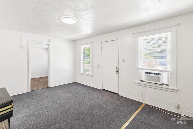 carpeted entryway featuring baseboards, a textured ceiling, and cooling unit