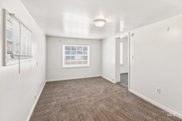 empty room featuring baseboards and carpet
