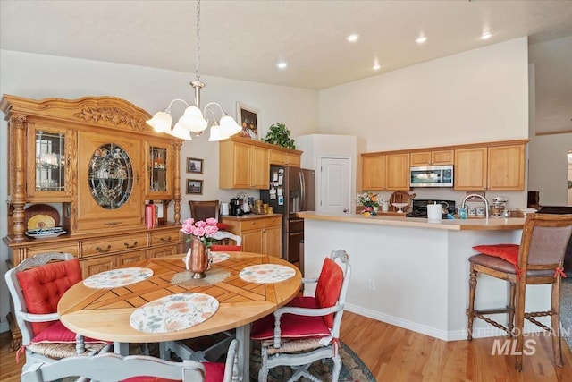 562 Castle Rock Ave, Middleton, ID 83644 - dining area with a chandelier, a high ceiling, light wood-style floors, and recessed lighting