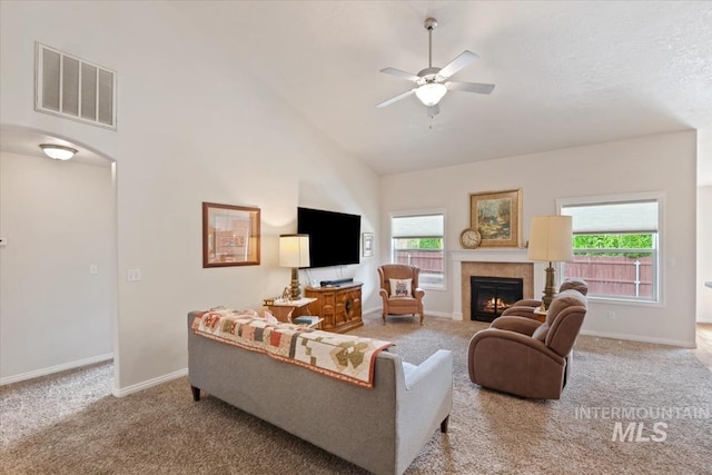 562 Castle Rock Ave, Middleton, ID 83644 - carpeted living area with high vaulted ceiling, ceiling fan, baseboards, a tiled fireplace, and arched walkways