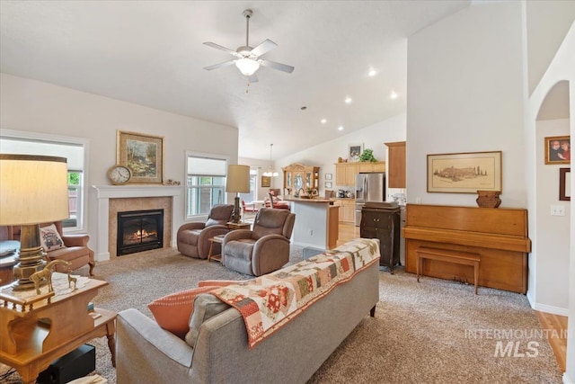 562 Castle Rock Ave, Middleton, ID 83644 - living area with light colored carpet, ceiling fan, vaulted ceiling, a tiled fireplace, and baseboards
