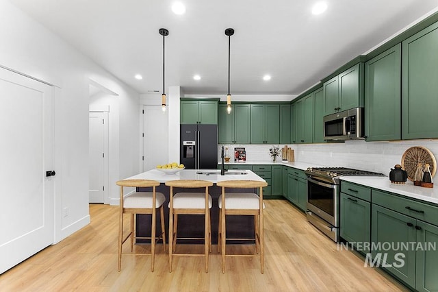 434 E Presidio Ln Lot 12/01, Eagle, ID 83616 - kitchen with green cabinets, stainless steel appliances, a sink, light wood-type flooring, and light countertops