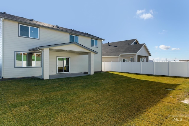 rear view of property with a lawn and a patio