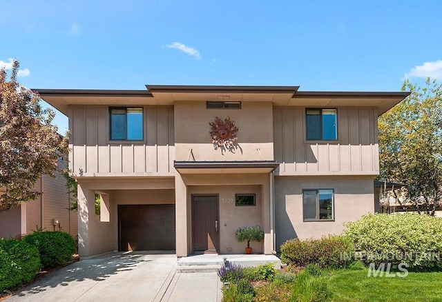 view of front of home featuring an attached garage, board and batten siding, concrete driveway, and stucco siding