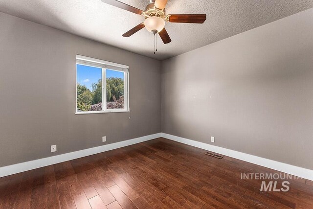 unfurnished room with baseboards, dark wood finished floors, and a ceiling fan