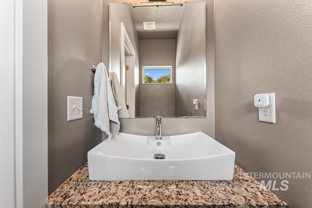 bathroom featuring a sink and a textured wall