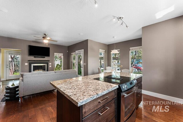 kitchen featuring stainless steel range with electric cooktop, ceiling fan, baseboards, dark wood finished floors, and dark brown cabinets