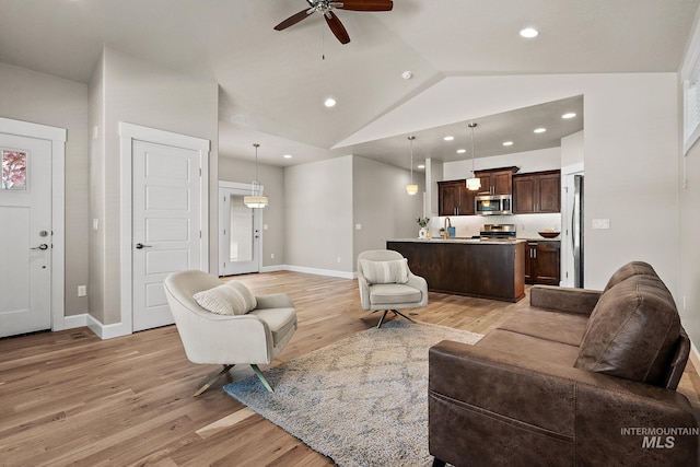 1457 Summerheights, Meridian, ID 83646 - living area with ceiling fan, vaulted ceiling, baseboards, and light wood finished floors