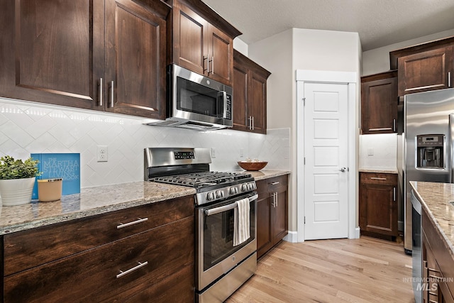 1457 Summerheights, Meridian, ID 83646 - kitchen with light wood finished floors, dark brown cabinets, light stone countertops, and stainless steel appliances
