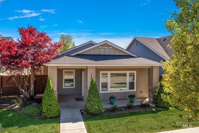 1457 Summerheights, Meridian, ID 83646 - view of front of property featuring a porch, board and batten siding, roof with shingles, fence, and a front lawn