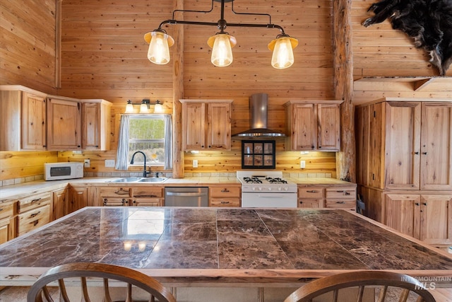 56 Burden Rd, Salmon, ID 83467 - kitchen featuring a sink, wall chimney range hood, white appliances, wood walls, and a breakfast bar area
