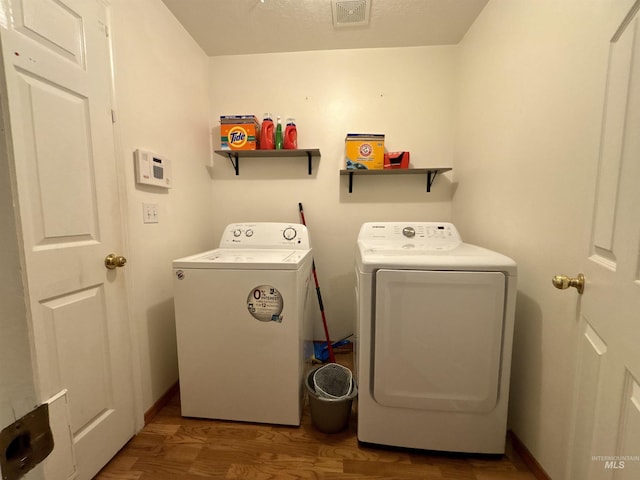 washroom featuring hardwood / wood-style flooring and washer and dryer