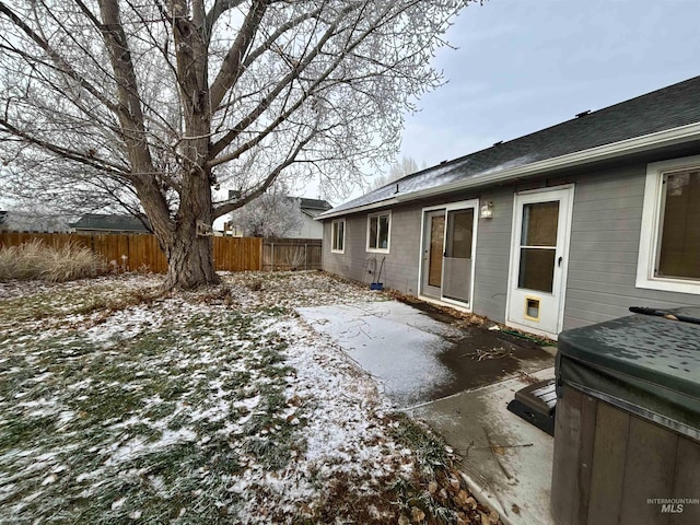 yard covered in snow featuring a hot tub and a patio