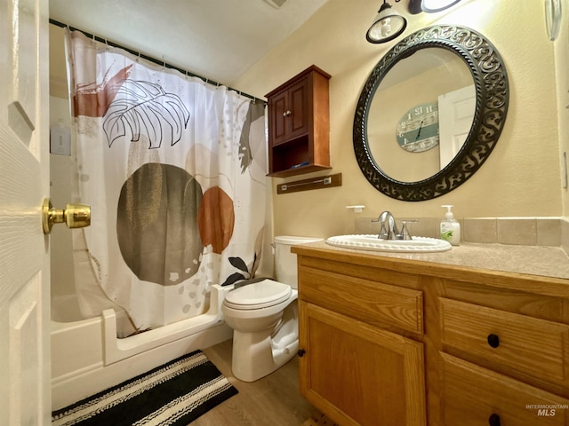 full bathroom featuring vanity, hardwood / wood-style flooring, shower / bath combination with curtain, and toilet