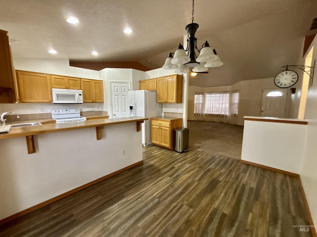 kitchen with lofted ceiling, sink, white appliances, a breakfast bar area, and decorative light fixtures