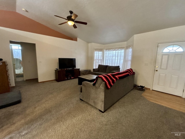 carpeted living room with ceiling fan and vaulted ceiling