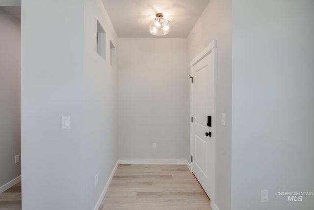 hallway featuring an inviting chandelier and light wood-type flooring