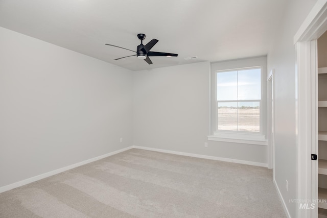 unfurnished room with ceiling fan and light carpet