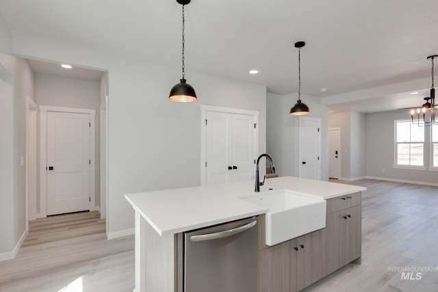 kitchen with sink, decorative light fixtures, a kitchen island with sink, light hardwood / wood-style flooring, and dishwasher