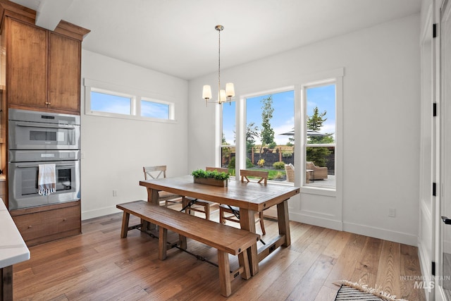 dining room with a notable chandelier and light wood-type flooring