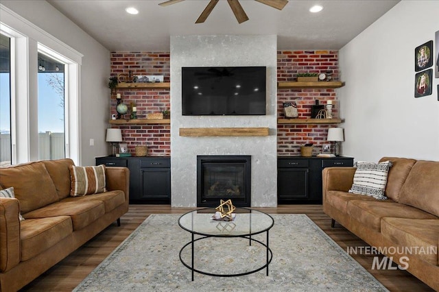 living area with a fireplace, wood finished floors, a ceiling fan, and recessed lighting