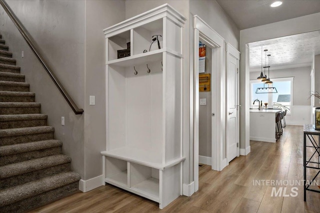 mudroom featuring light wood-type flooring, baseboards, and recessed lighting