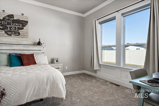 carpeted bedroom featuring ornamental molding, visible vents, and baseboards