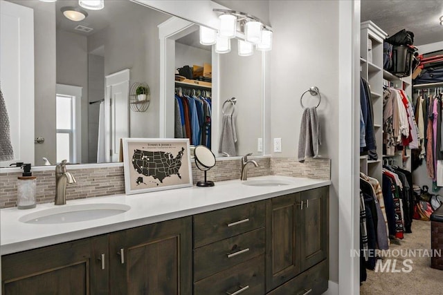 bathroom featuring tasteful backsplash, a sink, and double vanity