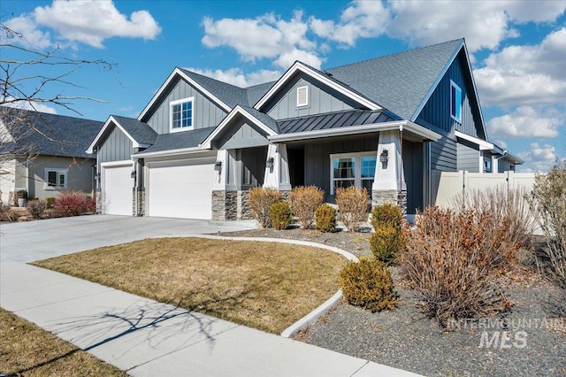 view of front of home featuring a standing seam roof, stone siding, board and batten siding, and fence