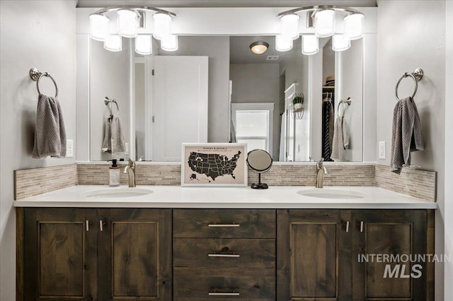 full bathroom with a sink, decorative backsplash, and double vanity