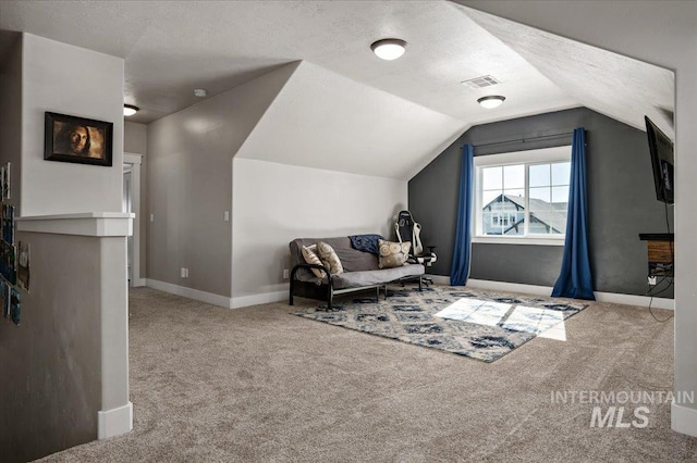 sitting room with baseboards, visible vents, lofted ceiling, a textured ceiling, and carpet floors