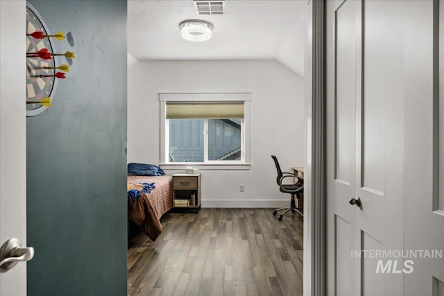 bedroom with wood finished floors, visible vents, and baseboards