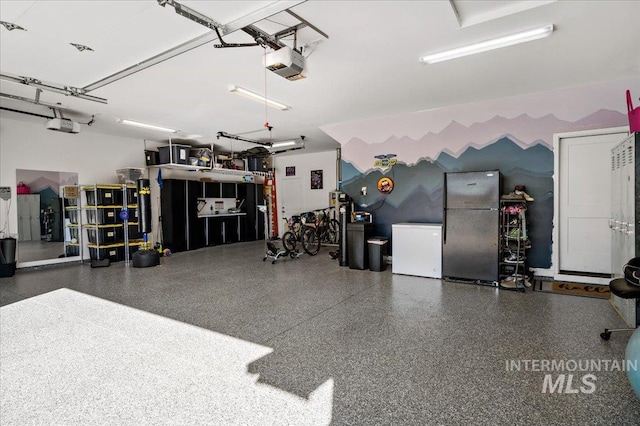 garage with fridge, freestanding refrigerator, and a garage door opener