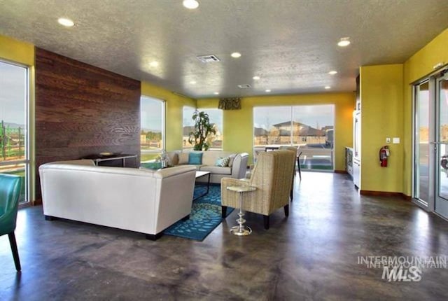 living room featuring plenty of natural light, concrete floors, and visible vents