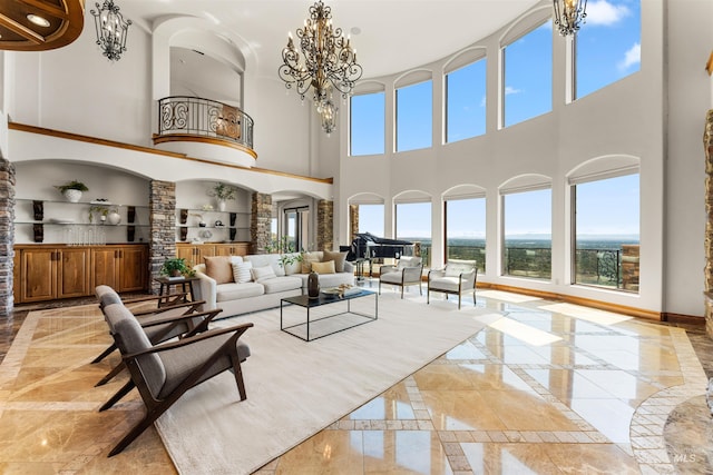 living room with a wealth of natural light, built in features, a high ceiling, and an inviting chandelier