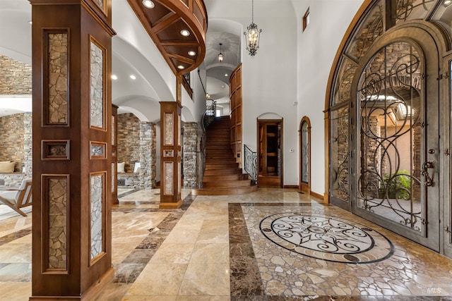 foyer entrance with a high ceiling, a wealth of natural light, and a notable chandelier