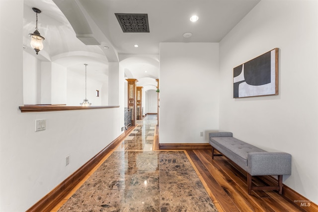 hall featuring dark hardwood / wood-style flooring and a notable chandelier