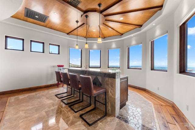 interior space featuring a raised ceiling, wood ceiling, and light hardwood / wood-style flooring