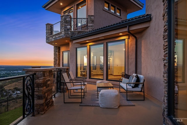 balcony at dusk with an outdoor hangout area