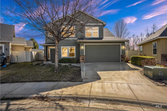 view of front of house with stone siding, roof with shingles, concrete driveway, and fence