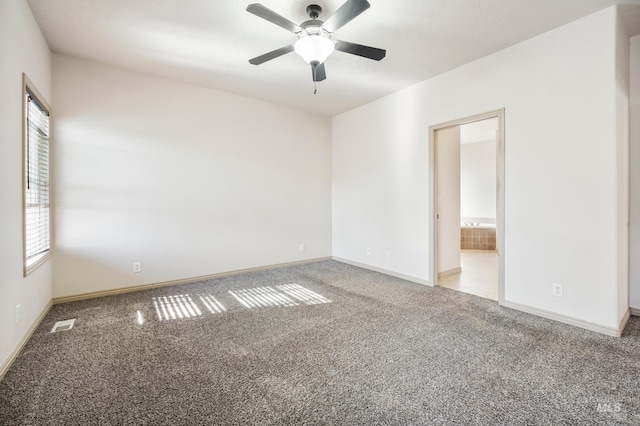 spare room featuring visible vents, baseboards, ceiling fan, and carpet flooring